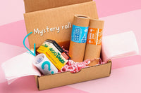 Example film bundle.  Four 35mm films in a box, surrounded by pink packing paper. Brands shown: Cute Camera Co, Kodak, and a mystery roll