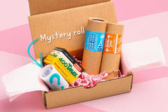 Example film bundle.  Four 35mm films in a box, surrounded by pink packing paper. Brands shown: Cute Camera Co, Kodak, and a mystery roll