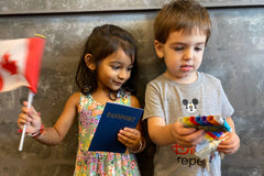 Kids holding a passport and crafts they made from their Wiggle Worms Preschool Around the World kit.