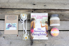 A red mug filled with three packets of Moonstruck milk chocolate, featured in the Peace & Pages monthly subscription box