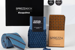 A SprezzaBox monthly subscription box featuring a watch, tie, socks, and a wooden comb for men's accessories