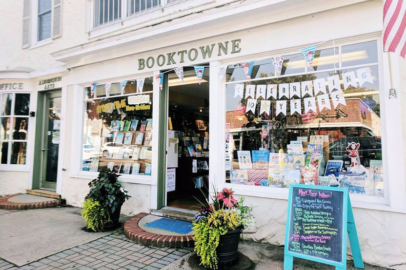 A beach scene with a subscription box from BookTIDE featuring great reads and colorful glass floats