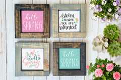 Brown and gray wood framed signs in various designs. Pink and blue "hello spring", bloom where you are planted signs.