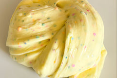 Dino Eggs Slime after being created from Bored to Brilliant Slime Kit. Bright yellow with flecks of clay and glitter.