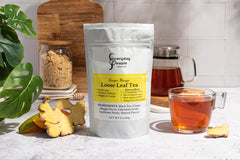 A gift bag of Everyday People Coffee & Tea's Great Tasting Sustainably Grown and Ethically Sourced Loose Leaf Tea Subscription next to a cup of tea.