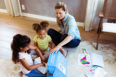 Mom and kids unboxing a BāKIT Box baking kit together, excited for a fun and educational baking experience.