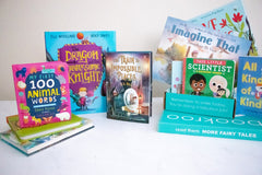 Two children reading books from Bookroo's Tween Book Club subscription on a colorful rug with additional books nearby