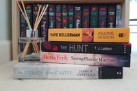 Brown subscription box filled with four surprise mystery books, featuring captivating stories and intriguing plots for genre enthusiasts.