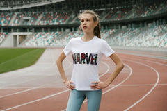 A y9oung girl preparing to run a race on a track. She is wearing workout pants and a Marvel Logo Tshirt.