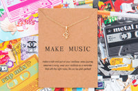 Music note necklace on backing surrounded by music themed paper coasters inn graphic styles with bold colors. 