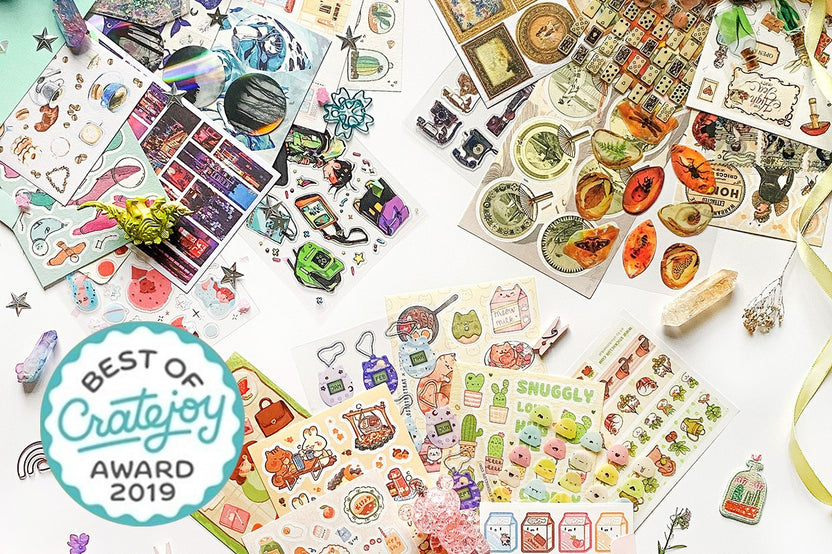 Items from a STICKII Club subscription box, including stickers of cactuses, animals, insects, planets and cute designs.