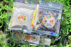 Components of the Lucky Slime Kit including jello, glitter, and clay. Clear glue in a foil pouch with sticker labels.