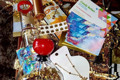 Items from The Stoney Babe subscription box including candy flavored rolling papers, a bong, a necklace and cards.
