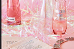 3 pink glasses, yellow napkins, pink and yellow confetti from a Uncorked Box subscription box.