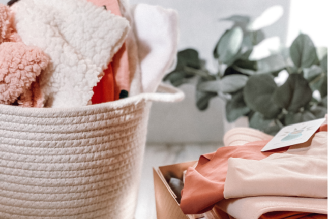 Items from a Baby and Sunshine subscription box including Soft and comfy clothes for babies and for mom.