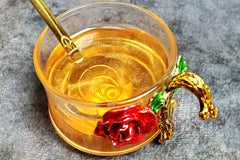 A golden shimmer tea with natural coloring from green tea and gold shimmer adding to its magic. One of my gold tea spoons sits in the cup.