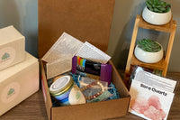 An example of one of the past boxes, filled with lava bead bracelet, Snack bar, Reiki infused chakra candle, rose quartz stone and more!