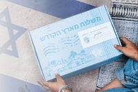 A woman holds a light blue Artza subscription box featuring designs inspired by the Christian Holy Land