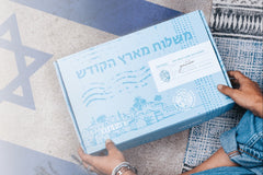A woman sitting on the floor, holding an Artza subscription box.