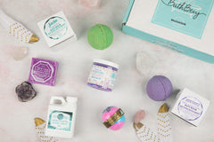 Bath Bevy Subscription box with bath bombs, bar soap, bubble bath jug, bath salts with amethyst, rose quartz and feathers