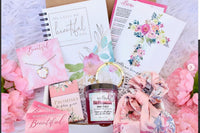 A cozy arrangement of fall-themed items in the Believer's Box VP, featuring socks, a candle, and a faith-inspired book