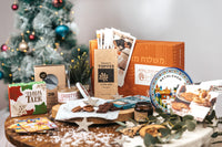 An Artza Israel Box subscription with desserts, recipe cards, and festive decorations on a table for Christmas
