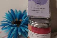 A gift of the Lavish Luxury Bath and Body Box and a flower on a table.