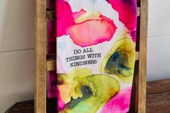 colorful pink and green tea towel with the words "do all things with kindness"