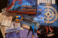 An unboxed picture of "Escape Atlantis" showing papers, props, and puzzles used when playing the game.