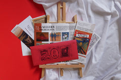 Scarlet Envelope Secret Society subscription box featuring a red envelope and various mystery-themed materials for puzzles