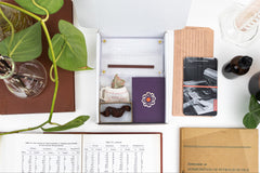 An open box displaying a selection of items that have been featured in past Matter boxes, featuring a coprolite fossil