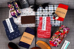 A SprezzaBox monthly subscription box featuring a watch, tie, socks, and a wooden comb for men's accessories