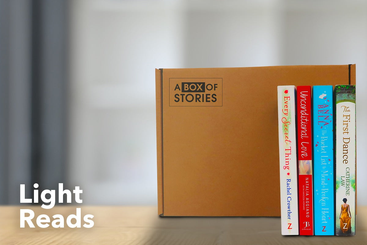 Brown subscription box filled with four light reading books, featuring charming stories and uplifting themes for easygoing book lovers.