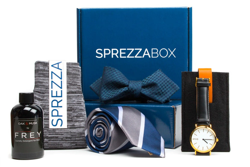 A SprezzaBox monthly subscription box featuring a watch, tie, socks, and a wooden comb for men's accessories