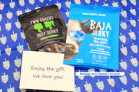 Baja Traditional jerky bag, Two CHicks Carne Asada bag, with a gift message situated on top of Hanukkah tissue paper. 