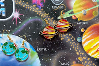 Colorful assortment of unique earrings including food and whimsical designs in the Monthly Earring Mania subscription box