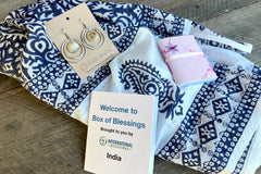 India Box of Blessings featuring a handblocked scarf, classic circled bone earrings, and a mini recycled notebook. 