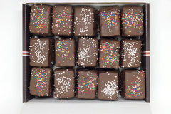 Nettie's Craft Brownies rainbow cookies sprinkles chocolate dipped aerial view of fifteen cookies in box.