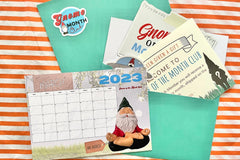 Gnome of the Month Club subscription box displayed on a front porch surrounded by neatly trimmed bushes