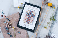 Colorful Artza subscription boxes stacked beside a festive green garland and decorative ornaments for Christmas