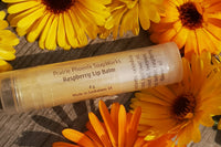 4 Natural, homemade lip balms  Raspberry,  Surrounded by calendula flowers. Picture taken in my back yard.