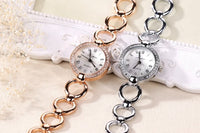 One gold and one silver timex watch with metal circle link giving a bracelet impression with a watch face attached. Elegant timepiece