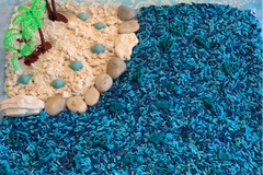 Sensory Play Beach Inspired Kit with blue dyed rice, rocks, dyed shells, palm trees and cloud dough 