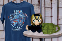 Captain America Tshirt hanging on a hanger. A Loki Plush Character and Hulk 3D sculpted fist mug sit on a table.