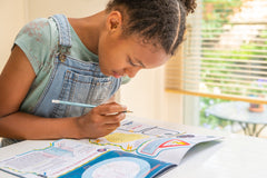 Girl doing puzzles in Whizz Pop Bang magazine – the awesome science magazine for kids aged 6 to 12. Lots to make and do each month!