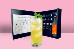 A Cocktail subscription box displaying a negroni cocktail in front of a gift box from Cocktail Crates