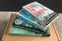 Brown subscription box filled with four surprise fiction books, offering captivating stories and diverse plots for literature lovers.