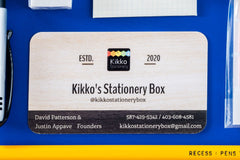 Close-up picture of notebook, pencils, stickers, pen, eraser, and business card. These items are an example of what may be included.