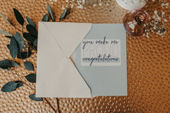 you make me so proud congratulations greeting card peeking out of the cream colored envelope included 