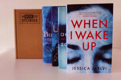Brown subscription box filled with four light reading books, featuring charming stories and uplifting themes for easygoing book lovers.